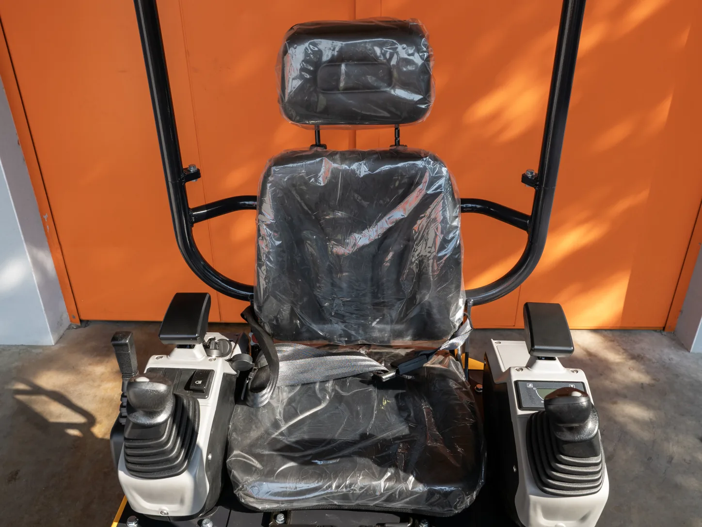 Poste de conduite de la mini-pelle Sonca SJW-18 PRO : siège à ceinture, joysticks sur accoudoirs et arceau canopy