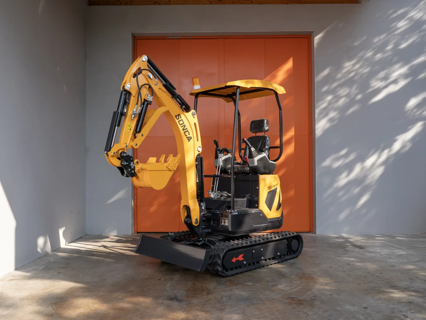 Mini-pelle Sonca SJW-18 PRO vue de trois quarts avant gauche, lame de remblayage et flèche orientable