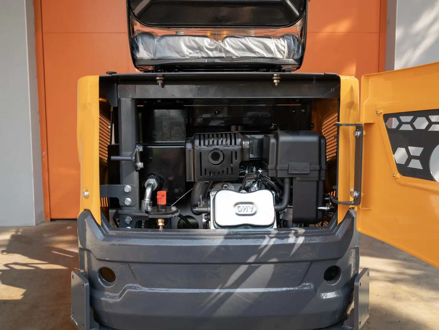 Compartiment moteur ouvert de la mini-pelle Sonca SJW-06 : moteur essence OHV, filtre à air et accès entretien