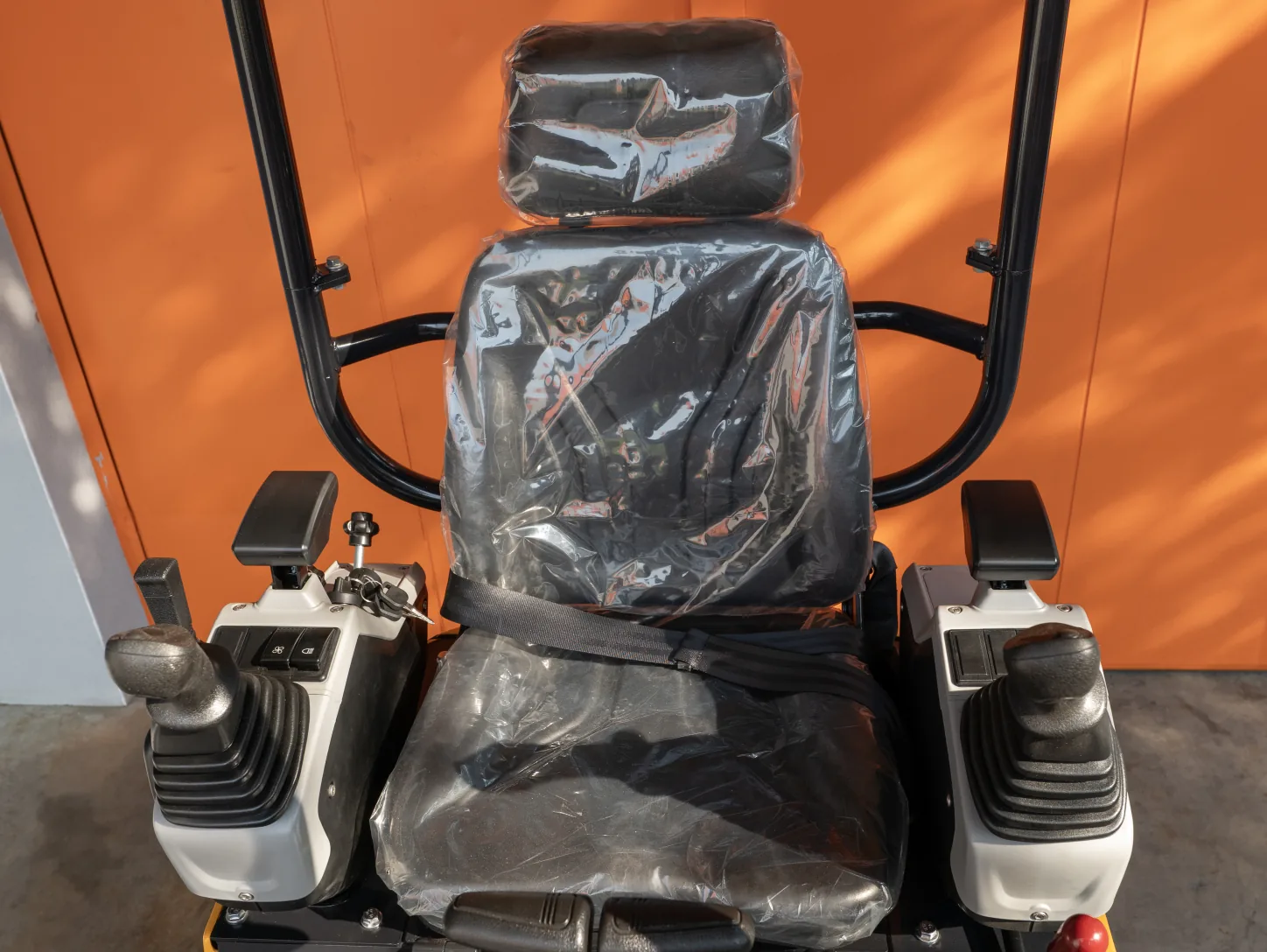 Poste de conduite de la mini-pelle Sonca SJW-12 P : siège à ceinture, joysticks intégrés aux accoudoirs et arceau canopy